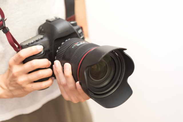 一眼レフカメラを持つ男性